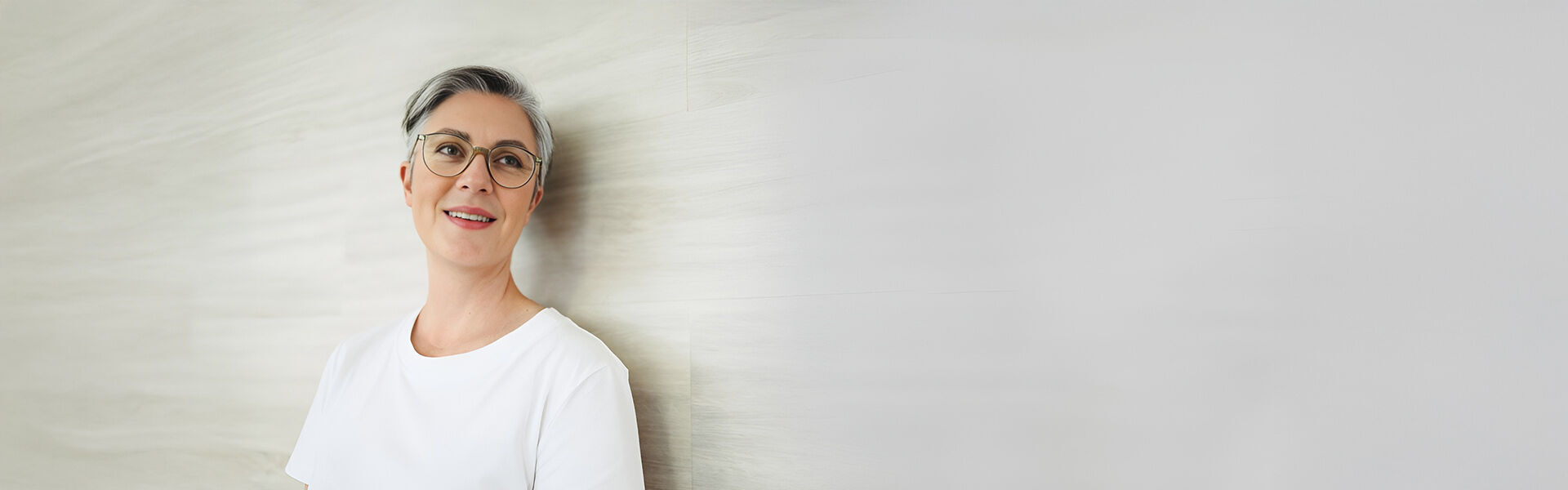 Lächelnde Frau mit grauem Haar und Brille